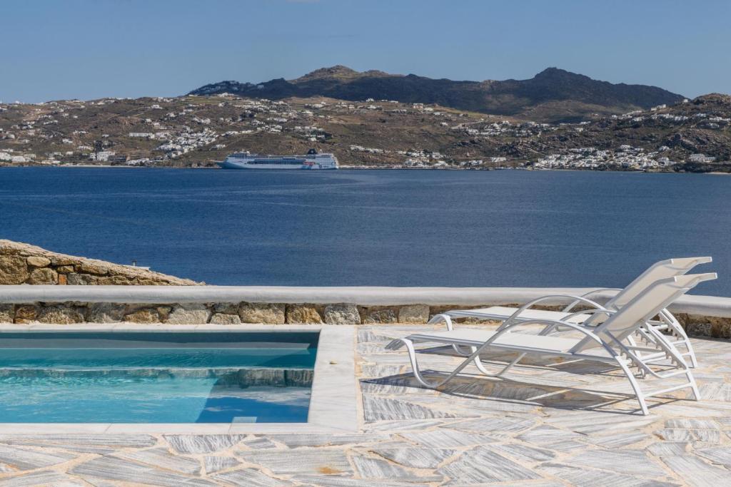 a white chair sitting next to a swimming pool at Lunar Villa in Glastros