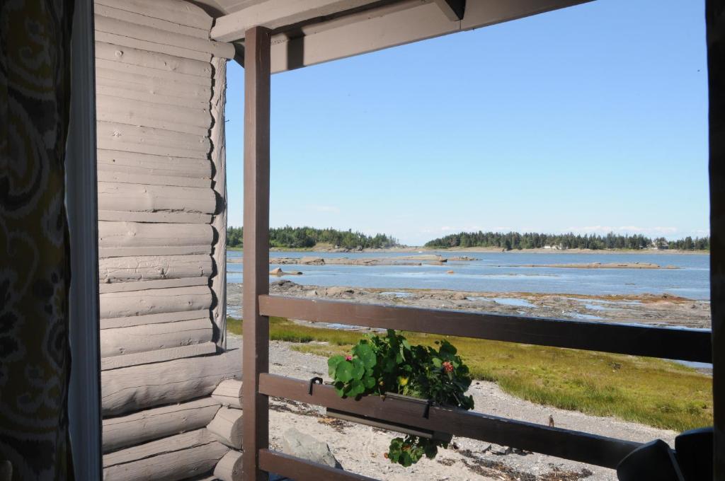 a window view of the beach from a house at Domaine Annie Sur Mer in Metis Beach