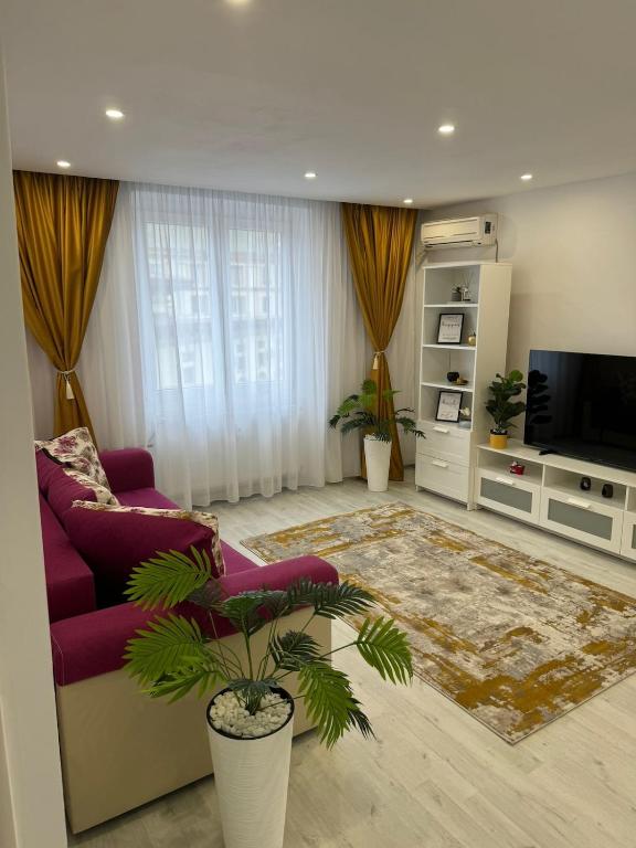 a living room with a purple couch and a tv at Ultracentral style apartment! in Craiova