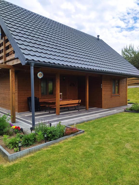 a wooden cabin with a bench in the yard at Dom letniskowy Krzyś in Przejma Wielka