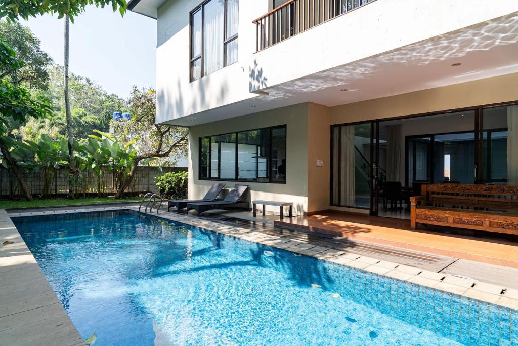 a swimming pool in front of a house at Oyama City View Villa 4 Bedrooms With a Private Heated Swimming Pool and a Billiard Table in Bandung