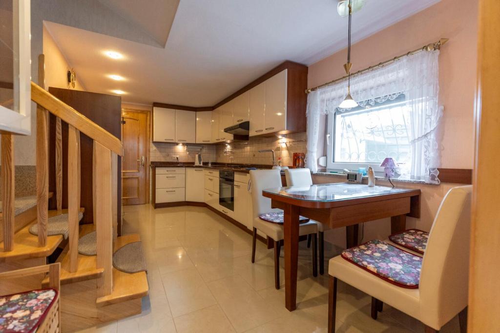 a kitchen with a sink and a table with chairs at Dom przy plaży in Giewartów