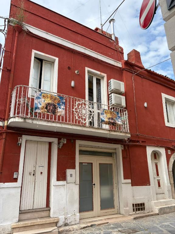 a red building with a balcony on it at Dimora Via Roma in San Severo