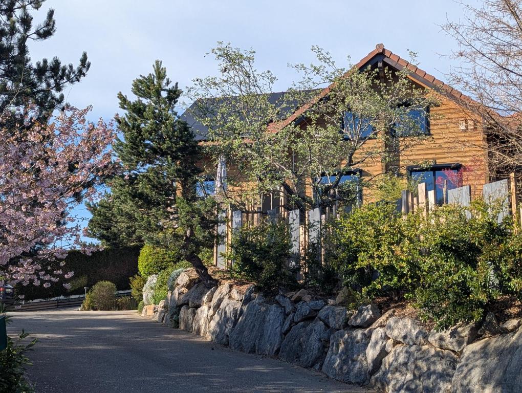 a house with a fence and a stone wall at Le Ptit Beccon in Cruseilles