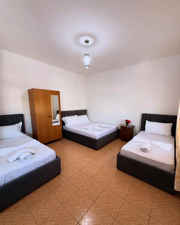 a room with three beds and a mirror at MARE Hotel Velipoje in Shkodër
