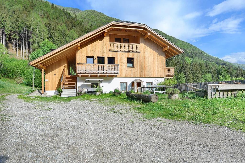a large wooden house with a balcony on a mountain at Felderhof in Villa Ottone