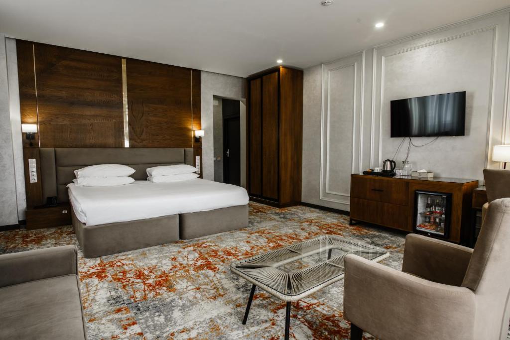a hotel room with a bed and a tv at Dostyk Mildom Almaty in Almaty