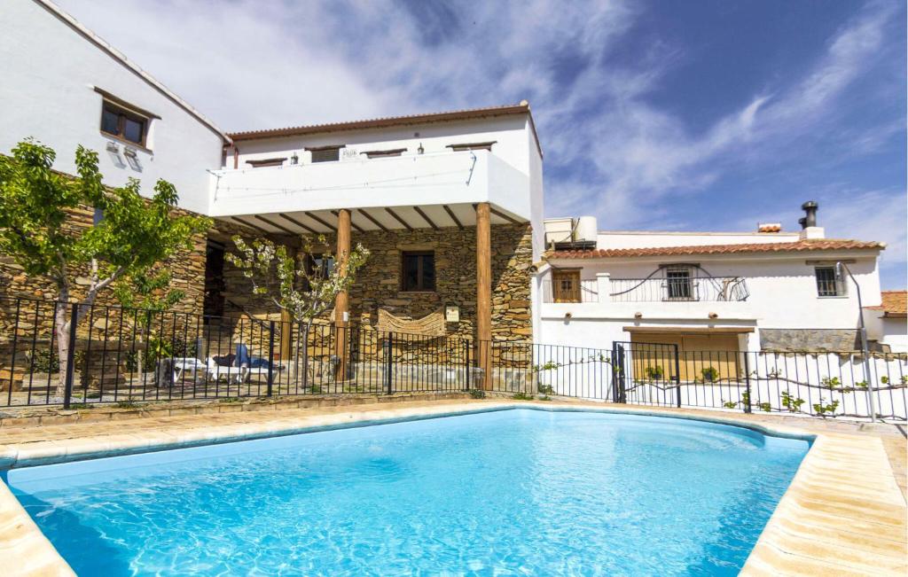 a swimming pool in front of a house at El Museo in Laroya
