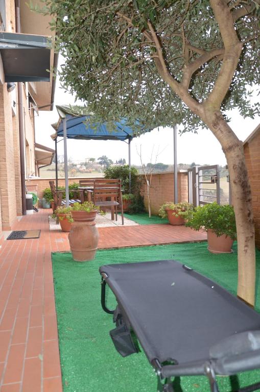 a ping pong table on a green lawn with a tree at Appartamento Gori in Siena