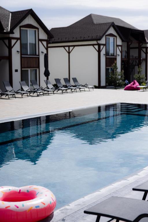 a swimming pool with chairs and an inflatable at My Home Apartments in Berehove