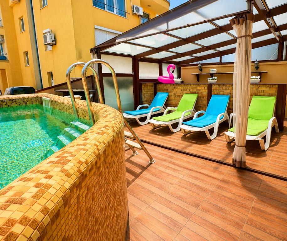 a patio with chairs and a swimming pool at Хотел ЮГ in Primorsko