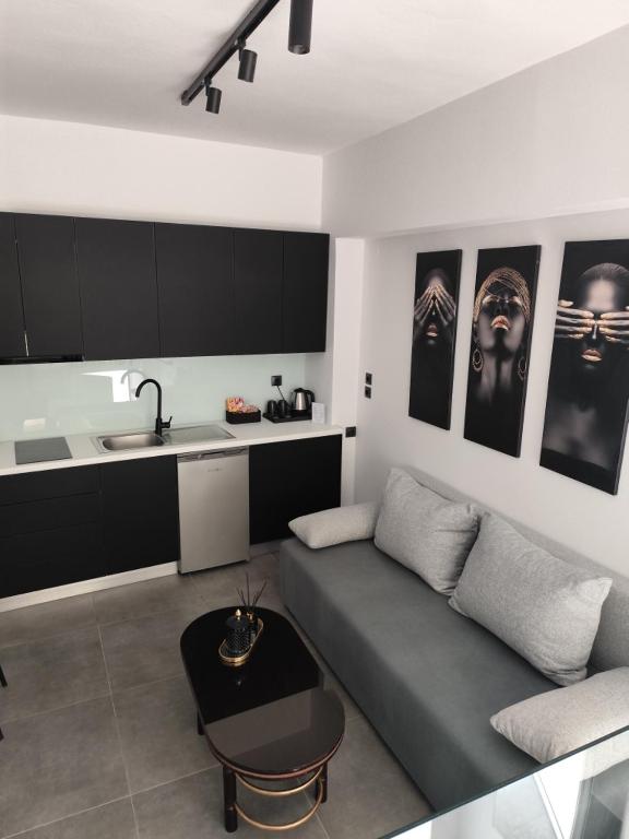 a living room with a couch and a kitchen at Studio Eleni in Plomari