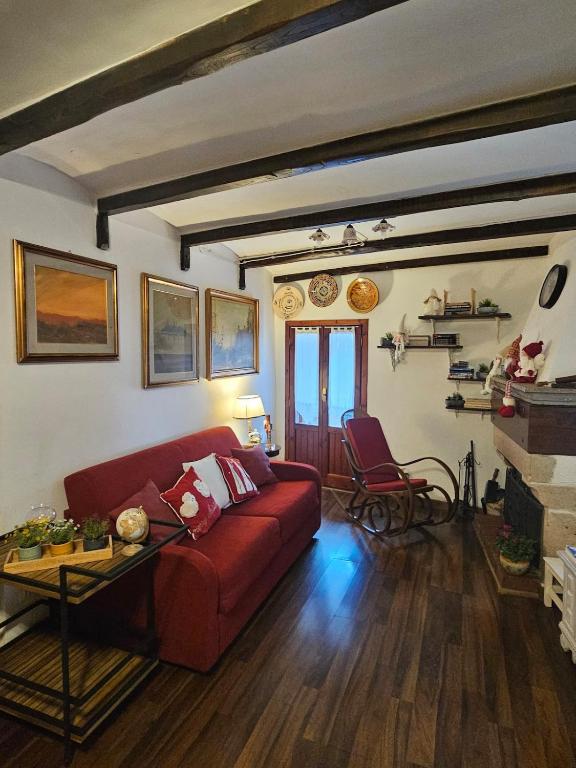 a living room with a red couch and a table at Casina Giulia in Capistrello
