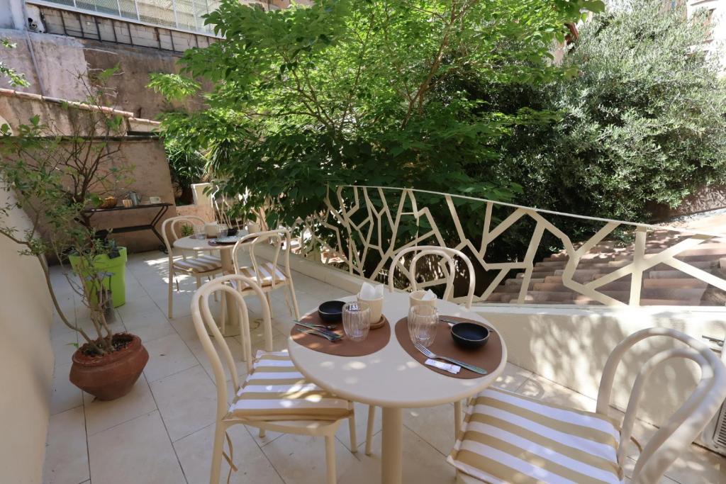 a patio with tables and chairs on a balcony at Boutique Hôtel Azur in Marseille