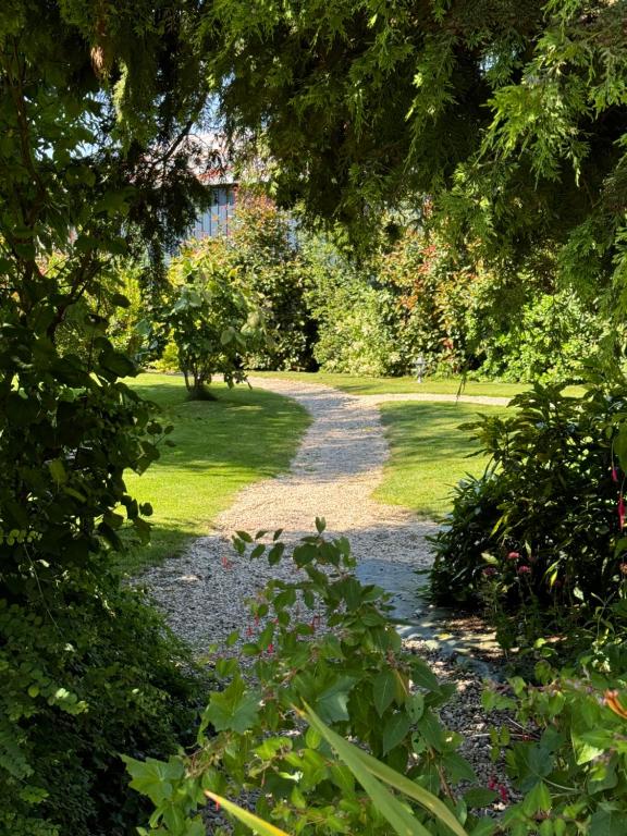 a path through a garden with trees and grass at Les Gîtes des Portes de Bretagne in La Chapelle-Saint-Aubert