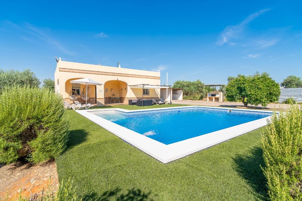 a swimming pool in the yard of a house at Casa Rural Villa Manantial in La Puebla de Cazalla