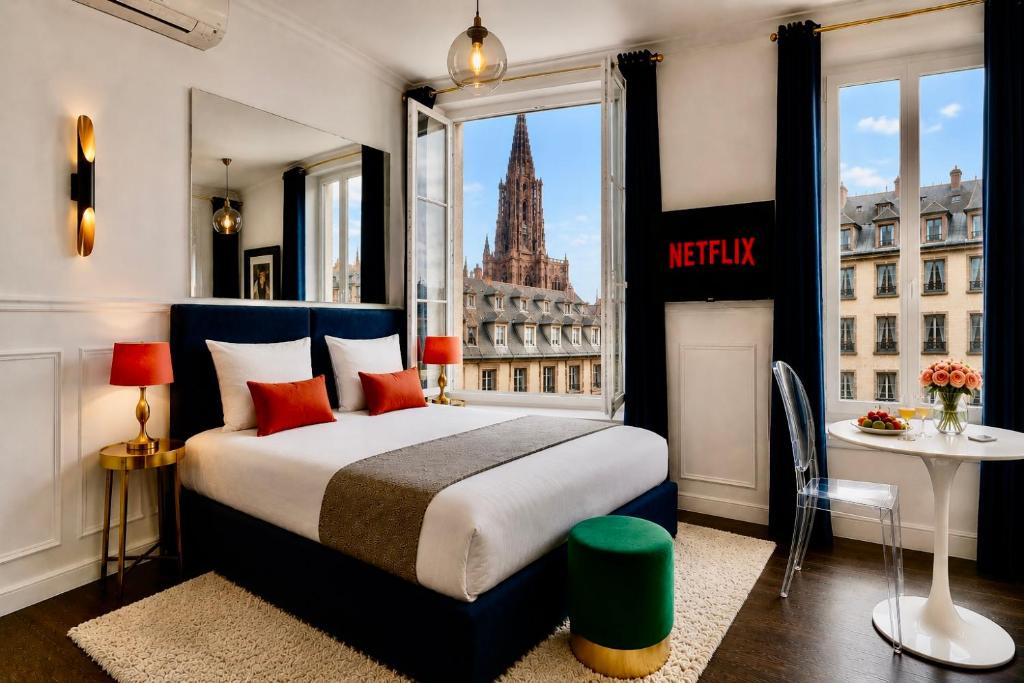 a bedroom with a bed with a view of a city at LIFE CATHEDRALE City-Center Place Gutenberg in Strasbourg
