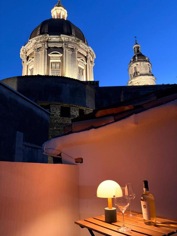 a building with a table with a lamp and wine glasses at Casa Van Gogh Catania in Catania