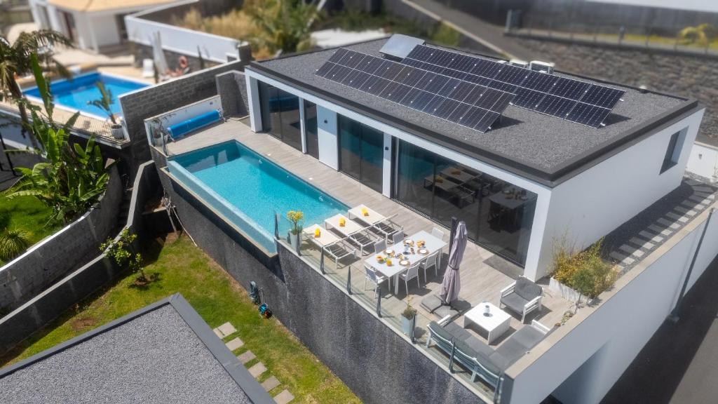 an aerial view of a house with solar panels on the roof at Villa Lilian by LovelyStay in Arco da Calheta