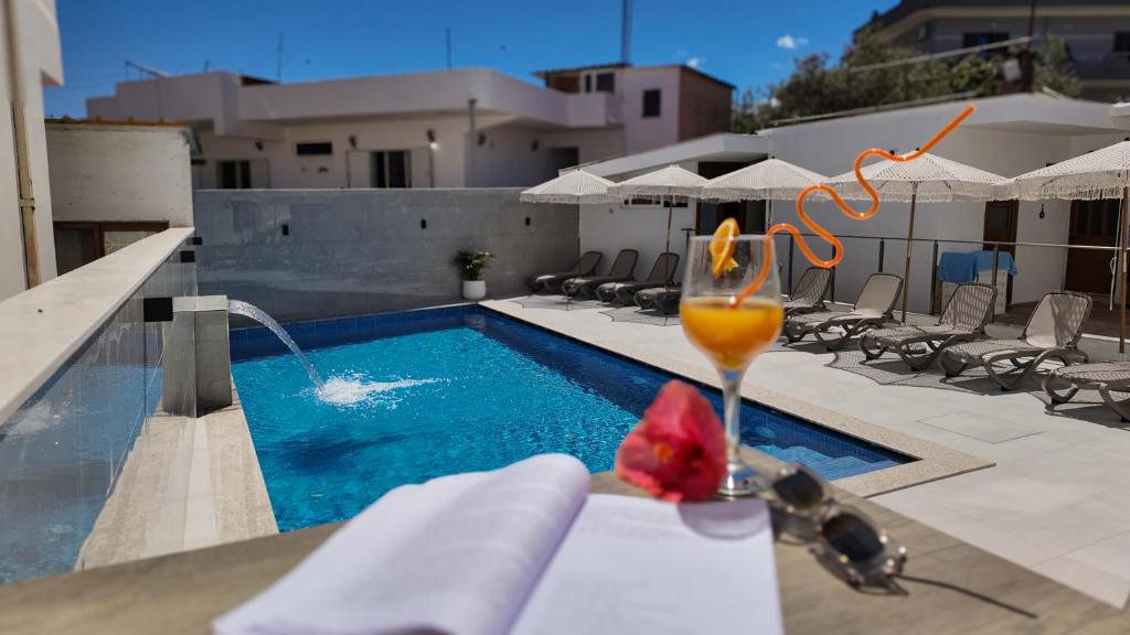 a drink sitting on a table next to a swimming pool at Vila Agushi in Ksamil