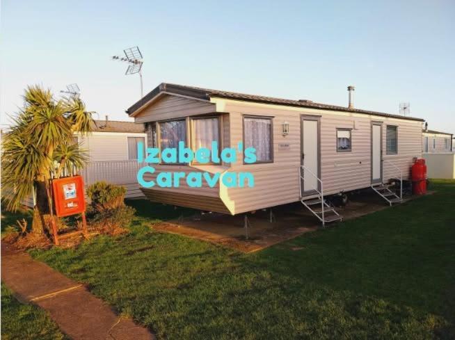 a mobile home with a sign on the side of it at Izabela's Caravan - Caravan 261 in Saint Osyth