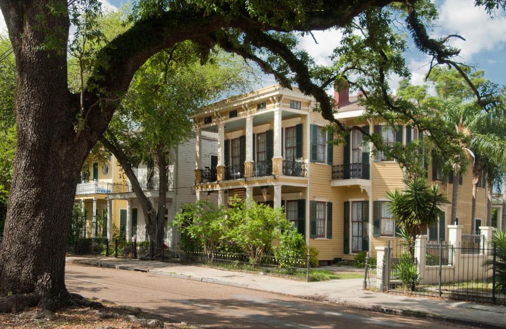 Una casa amarilla con un árbol delante. en HH Whitney House - A Bed & Breakfast on the Historic Esplanade, en Nueva Orleans