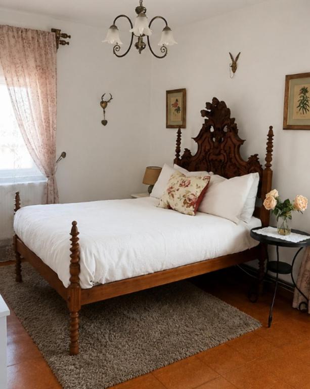 a bedroom with a bed with white sheets and a chandelier at Sunset Vista Apartment B in Mação