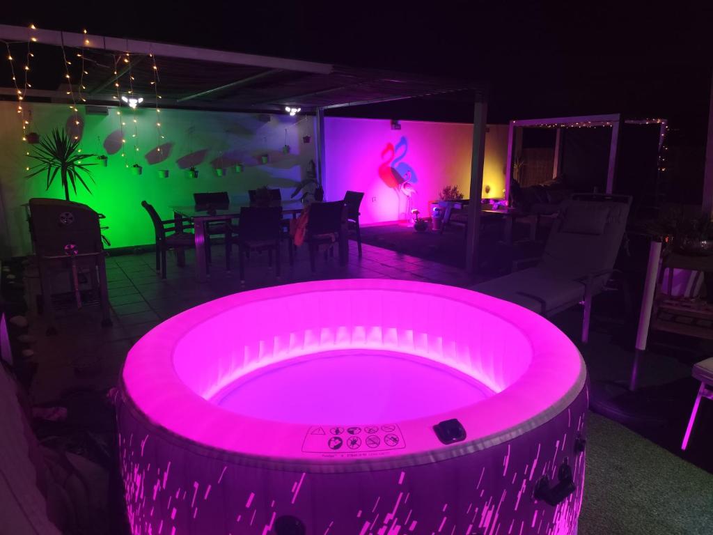 a pink hot tub in a room with a table at ÁTICO RILQUE, Apartamentos Independientes con Jacuzzi Privado y Terraza en Ronda in Ronda