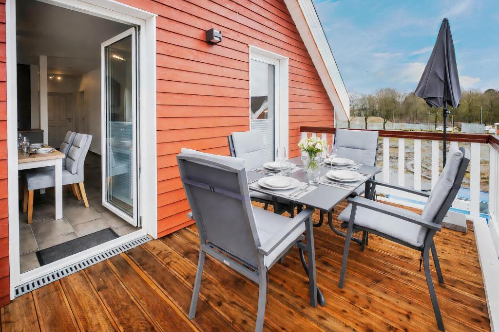 a patio with a table and chairs on a deck at Der VechteSchober - Nordhorn in Nordhorn