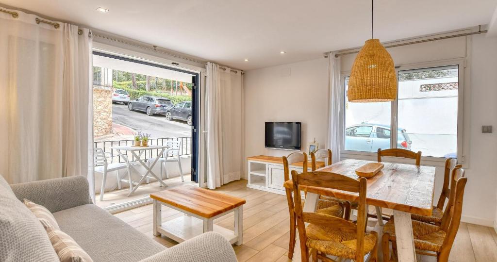 a living room with a table and chairs and a television at Sant Roc Apartments a Minute From The Beach in Calella de Palafrugell