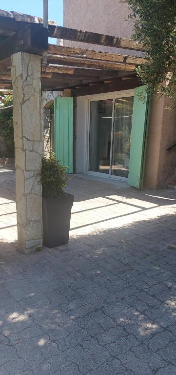 a building with a porch with a potted plant in front of it at La cigala in Le Pradet
