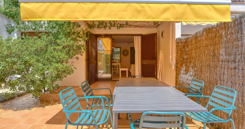 a table and chairs on a patio with a yellow umbrella at Penyagolosa in Calella de Palafrugell