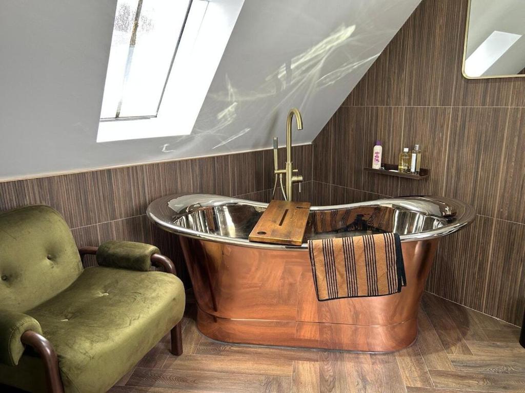 a bath tub in a bathroom with a chair at Planners House in Saint Monance