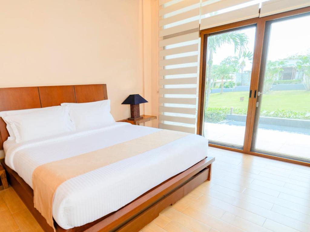 a bedroom with a large bed and a large window at The Park - Silang in Silang