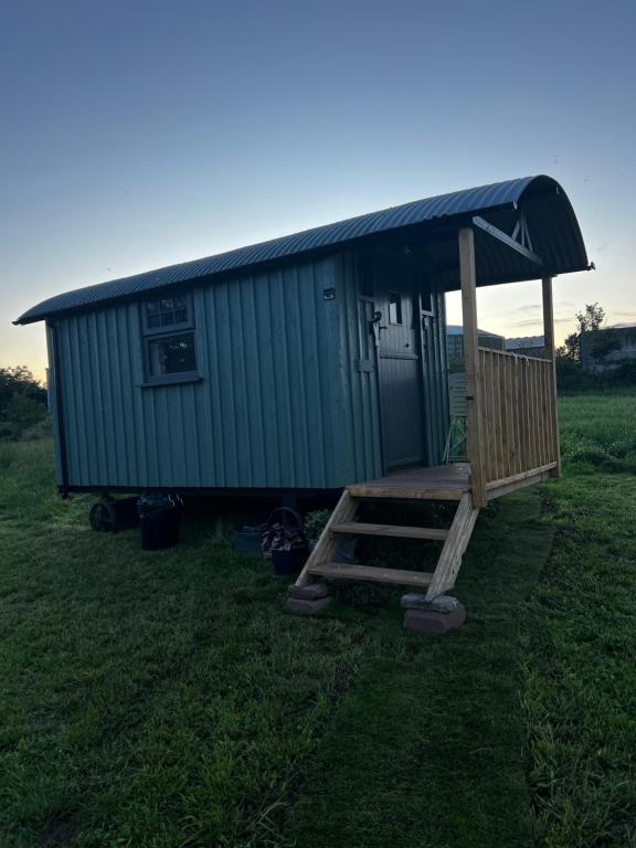 a small house with a porch and a staircase in a field at Shepherds Rest by the Wye in Fawley Station