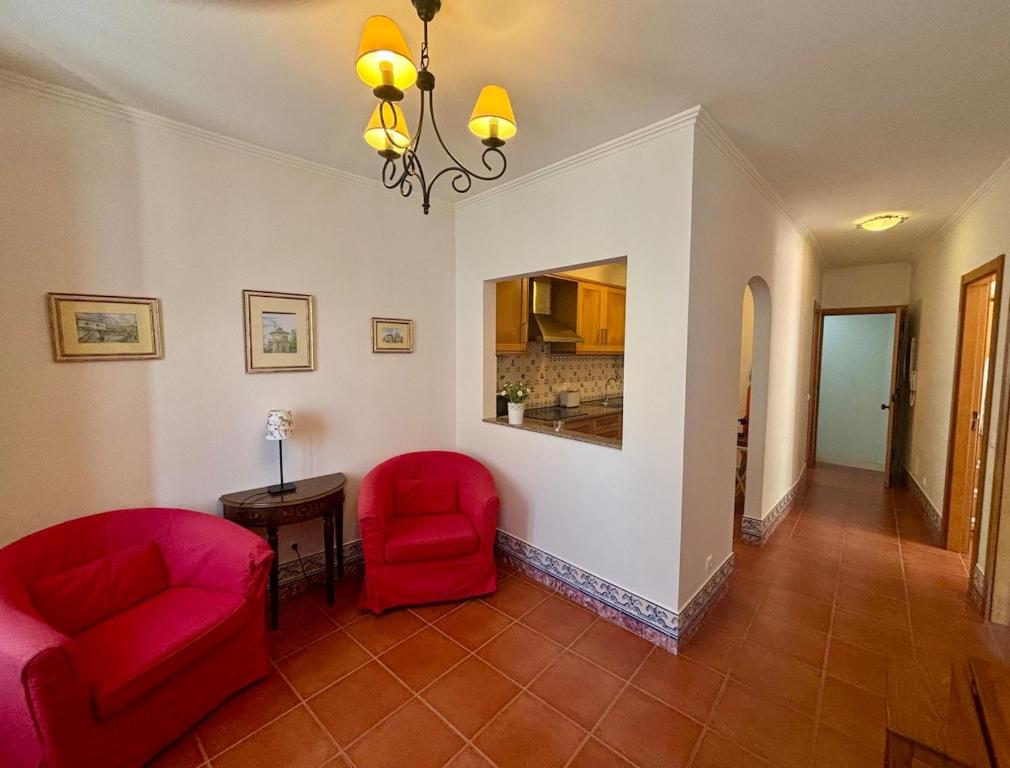 a living room with two red chairs and a table at CASA DA VILA 2, Sintra in Sintra