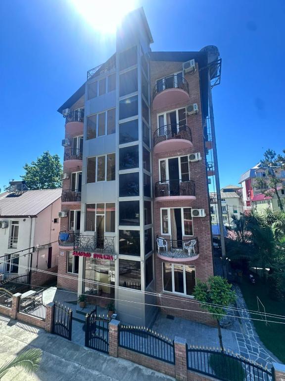 ein hohes Wohngebäude, auf das die Sonne scheint in der Unterkunft Hotel Evrazia in Ureki