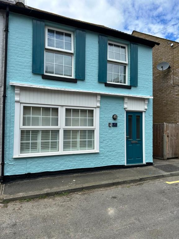 a blue house with white windows and a blue door at Pebble Beach in Deal