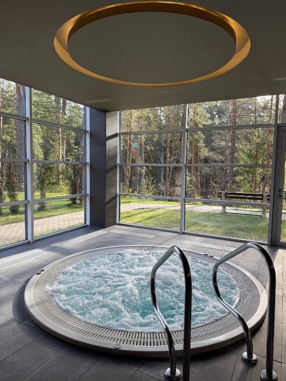 a hot tub in a room with a large window at UPA Medical SPA in Druskininkai