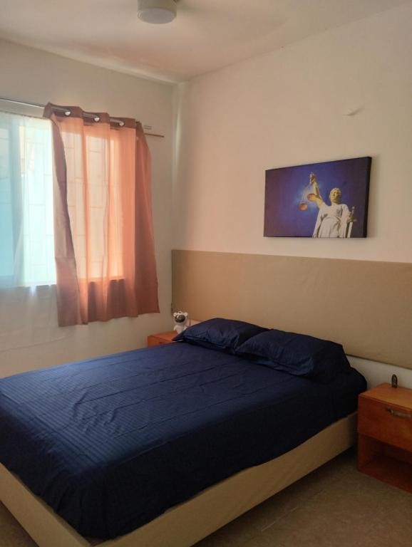 a bedroom with a blue bed and a window at Casa céntrica amplia en Veracruz in Veracruz