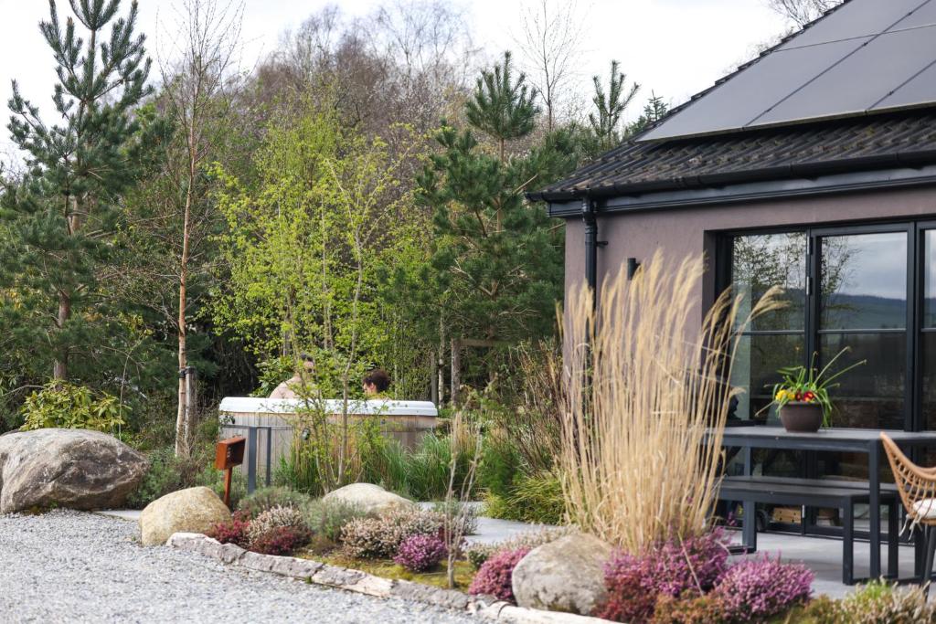 a garden with a bench and a house at The Deerstone Luxury Eco Hideaway in Laragh