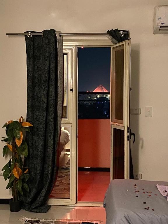 a bedroom with a sliding glass door to a balcony at 3pyramids view inn in Cairo