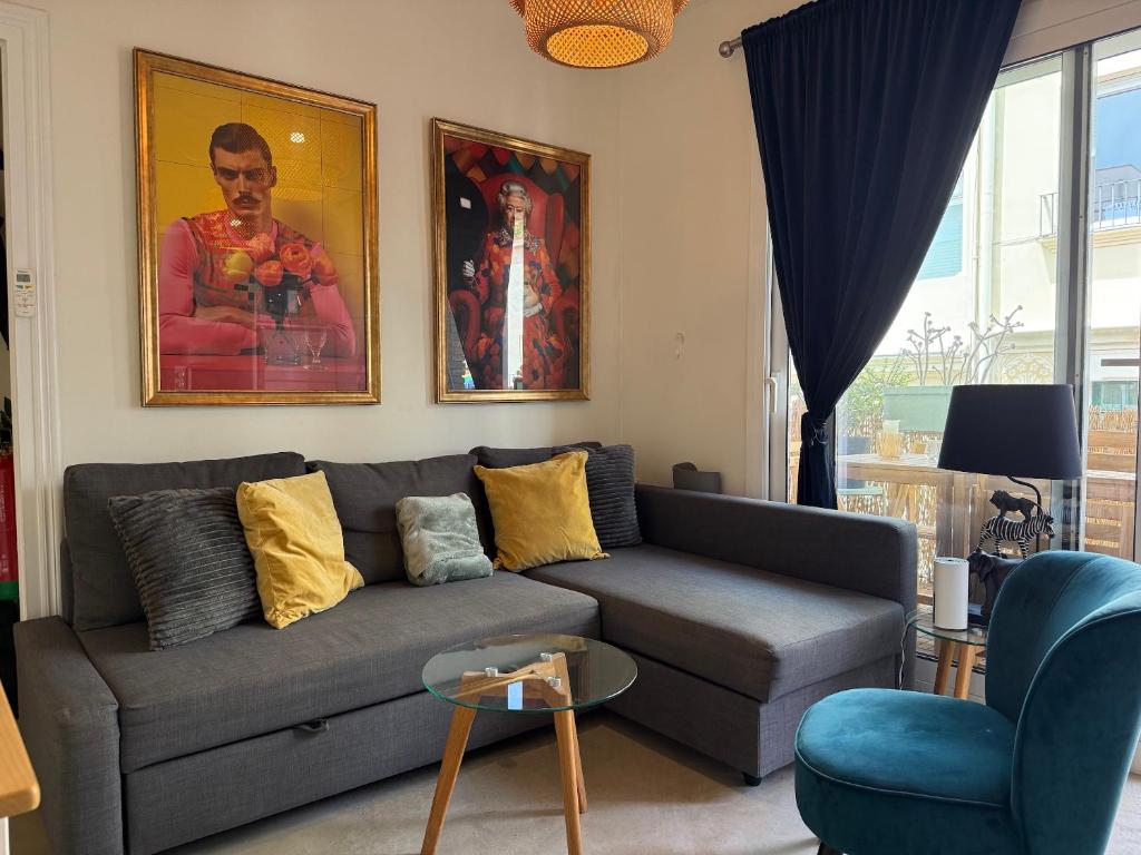 a living room with a gray couch and paintings on the wall at Piso Bonaire in Sitges