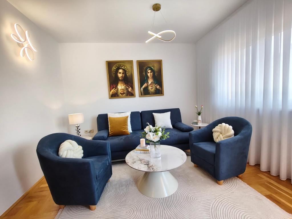 a living room with two blue chairs and a table at 2Hearts Apartment - Medjugorje in Međugorje