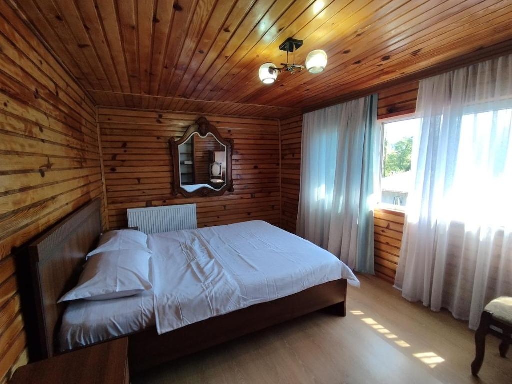 a bedroom with a bed in a wooden room at Entire 4th Floor for Guests in Batumi