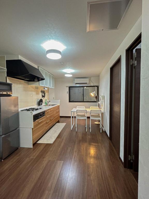 a kitchen with a stove and a table with chairs at COMMA House 川崎 in Kawasaki