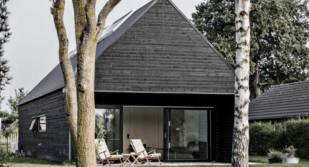a black house with a black roof at Sortehus - 100 steps from the finest beach in Vallebo