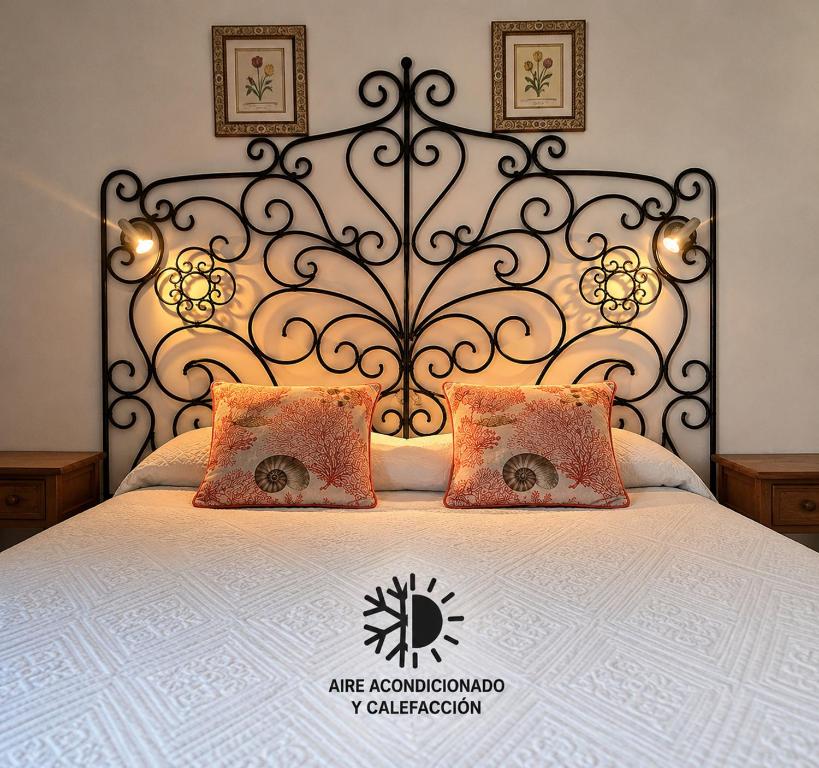 a bed with a metal headboard and two pillows at Pensión Los Volcanes in Fuencaliente de la Palma