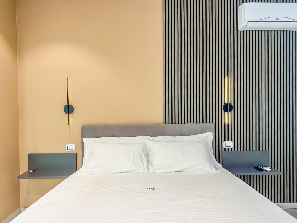 a bedroom with a large bed with white sheets at Miramare Suites in Vasto