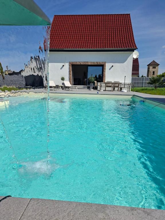 a swimming pool with a red roof at Ferienhaus Zerbst in Zerbst